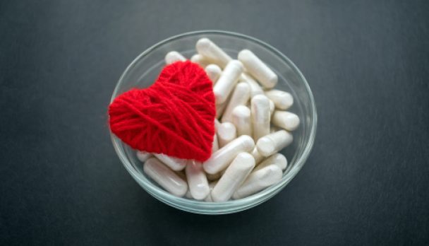 White,Veg,Capsules,And,Red,Thread,Heart,In,Glass,Bowl